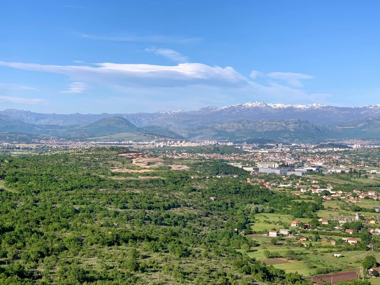 Podgorica a magasból, hófedte csúcsok alatt.